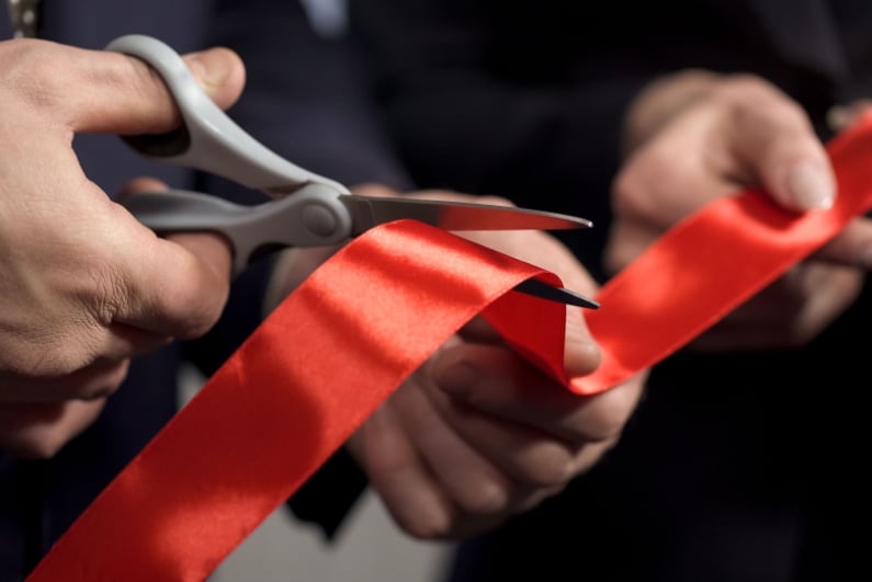 cutting a red ribbon